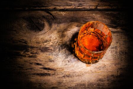whiskey with ice cubes on wooden backgroundの写真素材