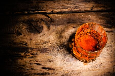 whiskey with ice cubes on wooden backgroundの写真素材