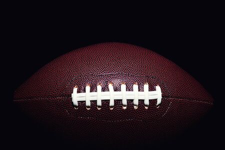 American football ball isolated on black backgroundの写真素材