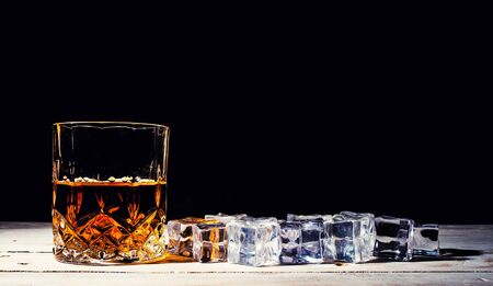 whiskey with ice cubes on wooden backgroundの写真素材