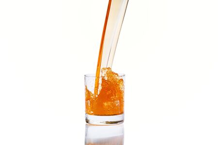 Whiskey with splash on white background, brandy in a glassの写真素材