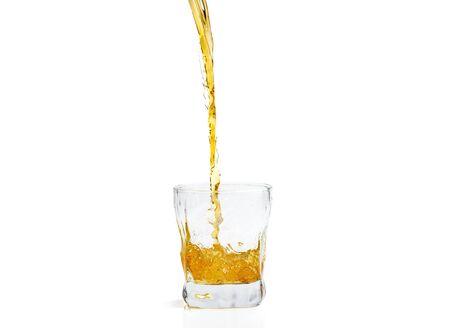 Whiskey with splash on white background, brandy in a glassの写真素材