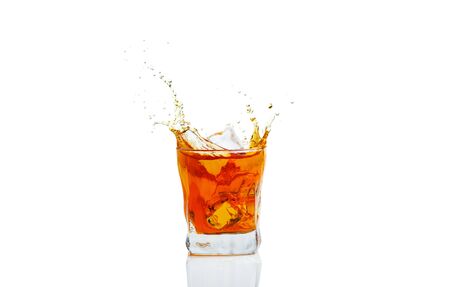 Whiskey with splash on white background, brandy in a glassの写真素材