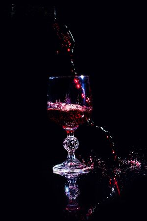Red wine pouring into wine glassの写真素材
