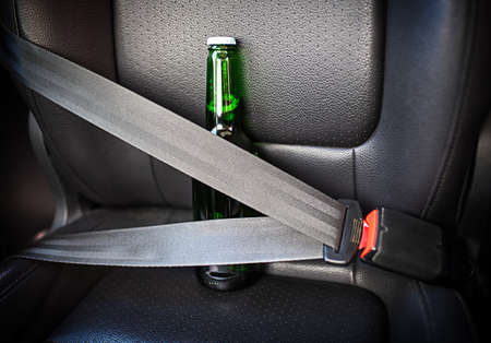 Bottle of alcohol fastened with seat belts. Drink and drive. Bottle of beer inside the car. Don't...