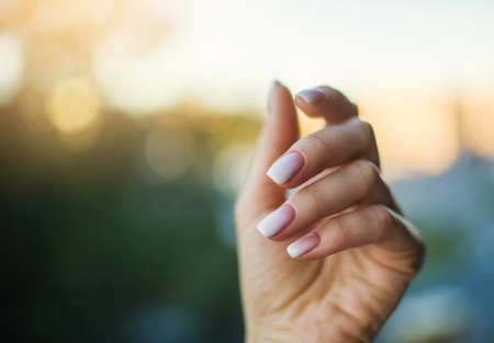Beautiful woman's nails with beautiful french manicure ombre peach and whiteの写真素材