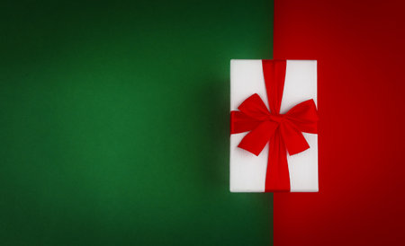 Red gift box with ribbon on green and red Christmas backgroundの写真素材