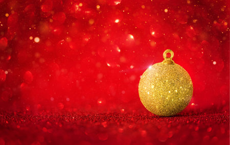 Golden Christmas ornaments on red holiday background with twinkle bokeh light.の写真素材