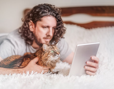 Man with a cat working at the tabletの写真素材