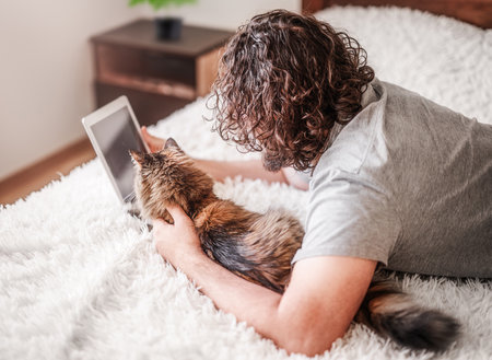 Man with a cat looking at the tabletの写真素材