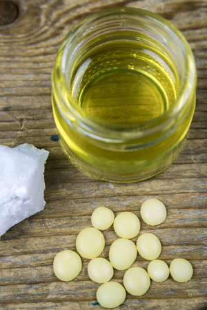Detail view on special ingredients and a jar of melted coco oil and cocoa butter for a DIY lotionの写真素材