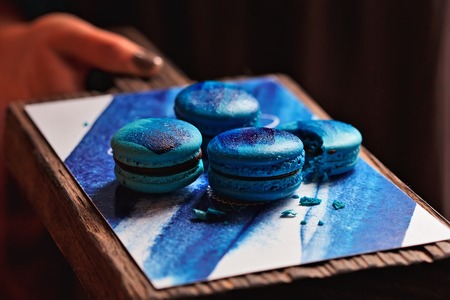 Blue colored french macarons on the wooden boardの写真素材