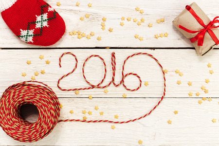 Happy New year 2016, numbers maden by wrapping thread of yarn on wooden background with Christmas decorationsの写真素材