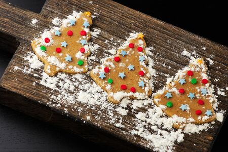 Christmas tree gingerbread cookie on wooden board stylish with powdered sugarの写真素材