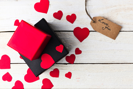Gift boxes and heart paper cut with craft label and love confession on white wooden background. Valentines day.の写真素材