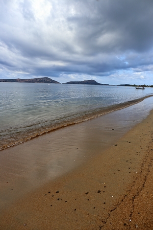 foamy wave of the sea splashing on a sandy beachの写真素材