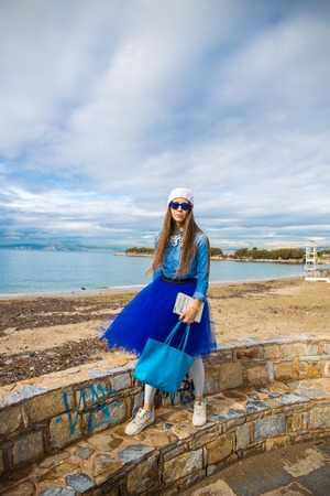 Pretty young girl in blue pettiskirt  in the sea on beachの写真素材