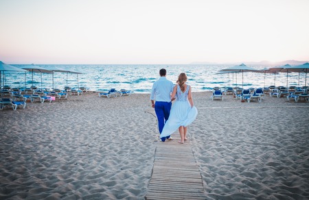 just married walking on a beach on sunsetの写真素材