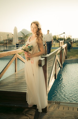 bride and groom posing on the bridgeの写真素材