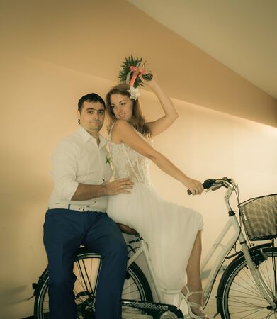 groom and bride posing with bicycle in the tunnelの写真素材