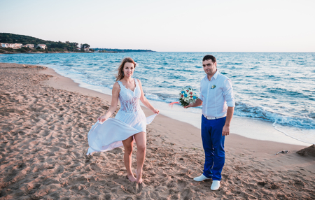 just married walking on a beach on sunsetの写真素材