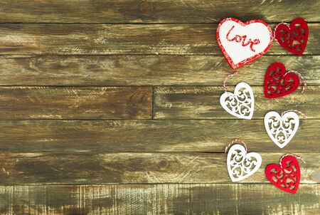 Red and white Hearts Hanging over Brown Wooden Background. Romantic Decoration For Valentines Day. Rustic, Retro Or Vintage Styleの写真素材