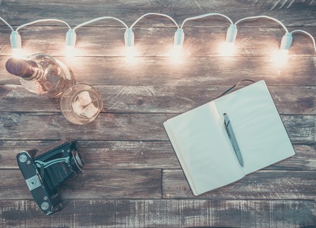 wooden background with light garland and notebook, vintageの写真素材