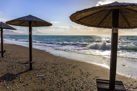 Umbreles on the sand beach with cloudy blue sky and sunの写真素材