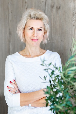 portrait of young blond woman with crossing handsの写真素材
