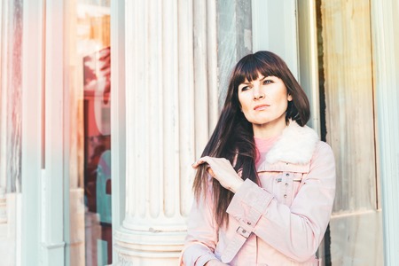 Portrait of a Stylish Pretty Young Woman in Autumn Fashion walking the city, near the window shopの写真素材