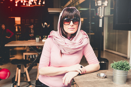 Portrait of a Stylish Pretty Young Woman in Autumn Fashion seating in cafe , Athens, Greeceの写真素材