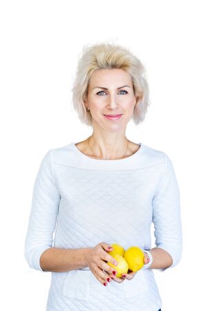 portrait of young blond woman holding lemons on white backgroundの写真素材