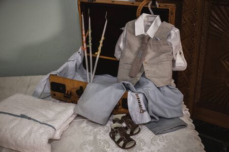 greek Orthodox christening objects - baby clothes, shoes, baptism oil, soap and candlesの写真素材