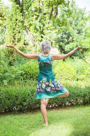 The back view, the girl practicing yoga and practicing yoga postures, amazing yoga postures in grassの写真素材