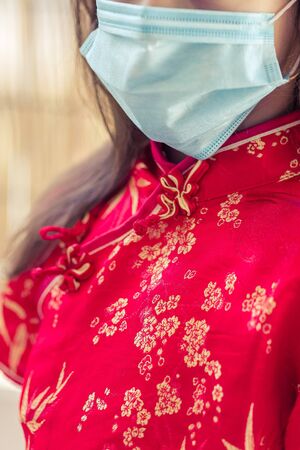 Children in traditional chinese dress in medicine mask. Coronavirus. Kid girl imprison at home for protection corona virus.coronavirus and epidemic virus symptoms.の写真素材