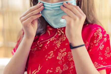 Children in traditional chinese dress in medicine mask. Coronavirus. Kid girl imprison at home for protection corona virus. coronavirus and epidemic virus symptoms.の写真素材