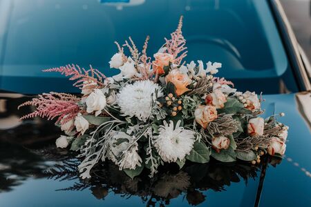 Fresh flowers on the car. Beautiful bouquet of flowers.Wedding bouquet in the background of the...