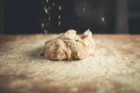 woman kneading bread dough on wooden tableの写真素材