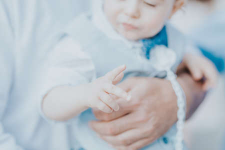 dad holds his son in his arms, a boy in a suitの写真素材