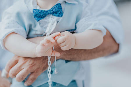 dad holds his son in his arms, a boy in a blue suitの写真素材