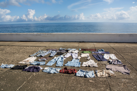 Drying clothes on the pavement at seafront, Baracoa, Cuba