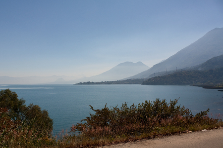 Lake Atitlan and volcanoes and road around it with view at San Pedroの写真素材