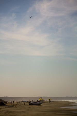 Zicatela beach and eagle in the sky boats and huts Puerto Escondido Mexicoの写真素材