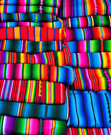 Pile of traditional textiles of different bright colors and patternsfor sale on the indigenous market, Antigua Guatemalaの写真素材