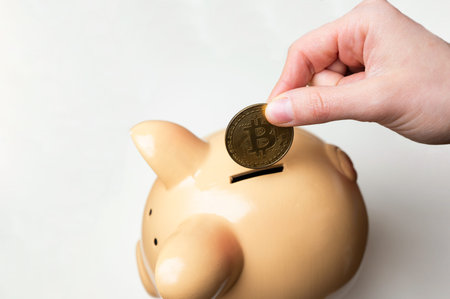 Capturing Detailed Moment Of Coins Being Placed Into Piggy Bank For Financial Disciplineの写真素材