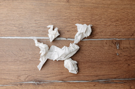Used Tissues Scattered Across Wooden Surface. Dried Tissues Are Strewn Across Wooden Flooringの写真素材