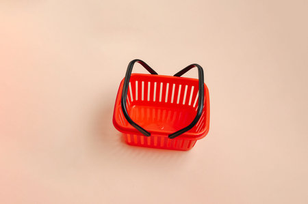 Empty Red Basket With Dark Handles Displayed On Smooth Surface For Retail Presentation