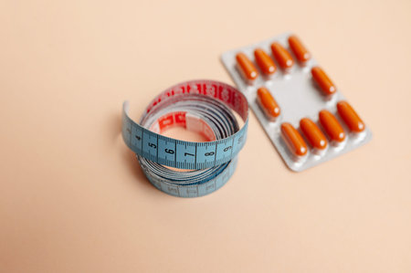 Arrangement Of Health Supplements With Measuring Tape On Peach Surface Emphasizing Diet