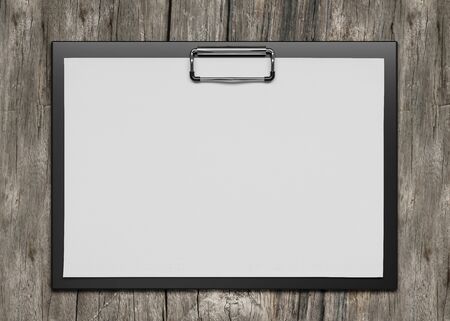 plastic clipboard with blank paper sheet isolated on wooden backgroundの写真素材