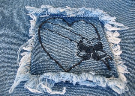 A denim patch containing a heart with a blank banner across it.